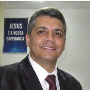 depoimento_4 Um homem de aparência austera, com cabelo longo e barba, se destaca em primeiro plano, expressando-se com intensidade enquanto aponta para a audiência à sua frente. Atrás dele, uma multidão de ouvintes, todos vestidos de forma simples e rústica, observa atentamente suas palavras. O cenário árido, repleto de colinas desérticas, reforça a atmosfera de um chamado urgente à reflexão e mudança. Esse cenário evoca a figura bíblica de João Batista, que prega no deserto e convoca as pessoas a se prepararem para um novo caminho.
