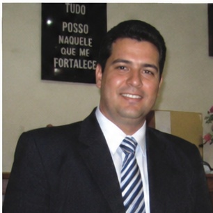 depoimento_9 Um homem de aparência austera, com cabelo longo e barba, se destaca em primeiro plano, expressando-se com intensidade enquanto aponta para a audiência à sua frente. Atrás dele, uma multidão de ouvintes, todos vestidos de forma simples e rústica, observa atentamente suas palavras. O cenário árido, repleto de colinas desérticas, reforça a atmosfera de um chamado urgente à reflexão e mudança. Esse cenário evoca a figura bíblica de João Batista, que prega no deserto e convoca as pessoas a se prepararem para um novo caminho.